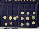 a purple box filled with lots of different colored coins