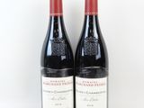deux bouteilles de vin rouge posées l'une à côté de l'autre sur une surface blanche