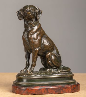 statue en bronze représentant un chien assis sur un socle en bois