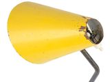 a yellow table lamp that is on a metal stand