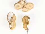 three pairs of gold earrings and a pair of earrings on a white surface