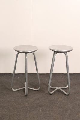 two metal stools sitting next to each other in a room