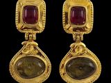 une paire de boucles d'oreilles en or ornées de pierres rouges et vertes