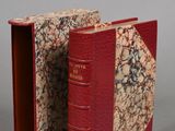 a red book that is open on a gray surface