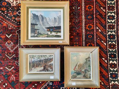 deux tableaux encadrés représentant des montagnes et un bateau, posés sur un tapis