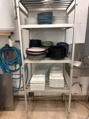 many plates and bowls stacked on a shelf in the kitchen