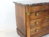 a wooden dresser with a marble top on a white floor