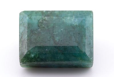 gros plan d'une pierre d'émeraude verte sur une surface blanche