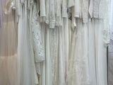 a lot of dresses hanging on a rack in a room