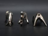 three pairs of silver earrings sitting on top of a black surface