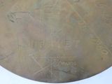 a close up of a metal plate with writing on it