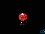 a red diamond in the dark with a reflection on the ground