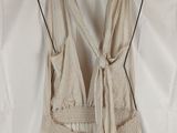 the back of a dress hanging on a hanger on a white sheet