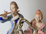 a figurine of a boy and a girl playing a musical instrument