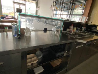 stainless steel counter top in a restaurant kitchen with lots of dishes on it