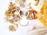 a pile of assorted jewelry on a white surface