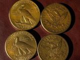 three gold coins sitting on top of a brown leather surface