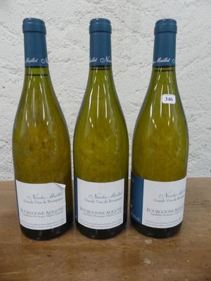 trois bouteilles de vin posées sur une table, l'une à côté de l'autre
