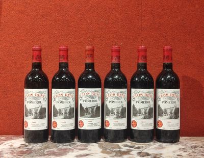 six bouteilles de vin rouge sont alignées sur une table