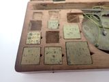 a wooden box with a clock and several different pieces of metal on it