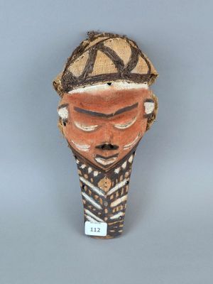 une image représentant un masque en argile coiffé d'un chapeau