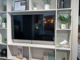 un téléviseur posé sur un meuble TV blanc dans un salon
