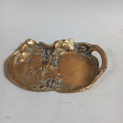 une assiette dorée ornée de fleurs sur un fond blanc