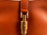 a close up of a brown leather purse with a brass lock