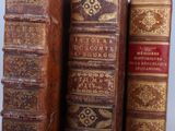 several old books are stacked on top of each other on a table