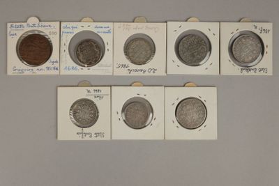 Plusieurs types de pièces sont exposés dans une vitrine.