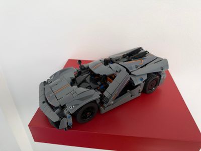 une maquette Lego représentant une voiture posée sur une plate-forme rouge