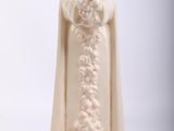 figurine d'une femme tenant un bouquet de fleurs dans ses mains