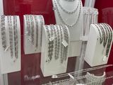 many necklaces and bracelets on display in a glass case