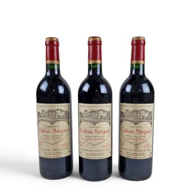 three bottles of red wine sitting next to each other on a white surface
