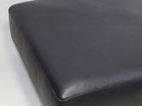 black leather ottoman with metal legs on a white background