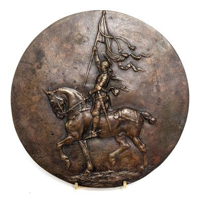 a bronze plaque of a man on a horse holding a flag