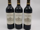trois bouteilles de vin posées sur une table blanche