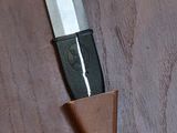 a knife that is laying on top of a piece of wood