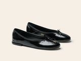 Les chaussures noires de la femme sont alignées sur une surface blanche