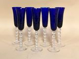 quatre verres à vin bleus posés les uns à côté des autres sur une table