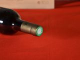 a bottle of wine sitting on a red table cloth