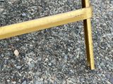 a yellow bench that is sitting on a gravel ground