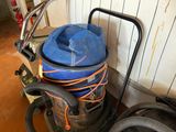 a blue bag on top of a vacuum in a room