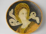 une assiette sur laquelle est représentée une femme faisant le signe de la paix