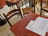 a table and chairs in a restaurant with papers on the table