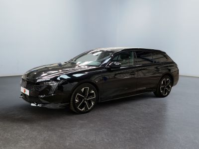 La voiture noire est garée dans une grande pièce au sol noir.