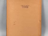 an old book with a brown cover sitting on top of a table
