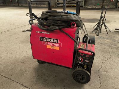 a small red machine with a hose on top of it