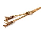 a close up of a pair of tassels on a white surface