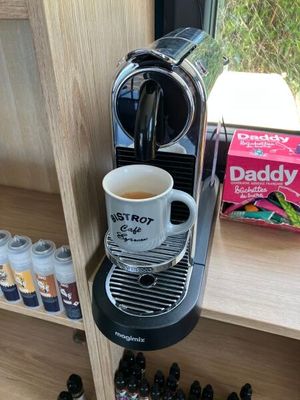 une cafetière posée sur une étagère à côté d'une tasse